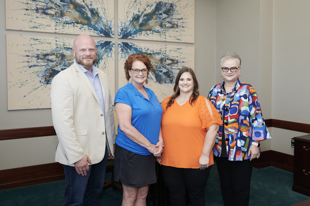 Staff Excellence Award recipients, Steven Koether, Debra Mikulin and Lacey Price take a photo with University President Alisa White. 